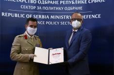 Assistant Minister Ranković presents the UK Defence Attaché, Colonel Ilić, with a certificate of appreciation